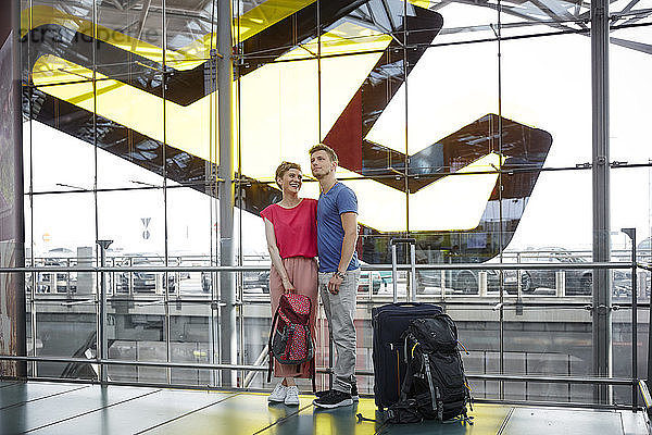 Lächelndes Paar steht auf dem Flughafen