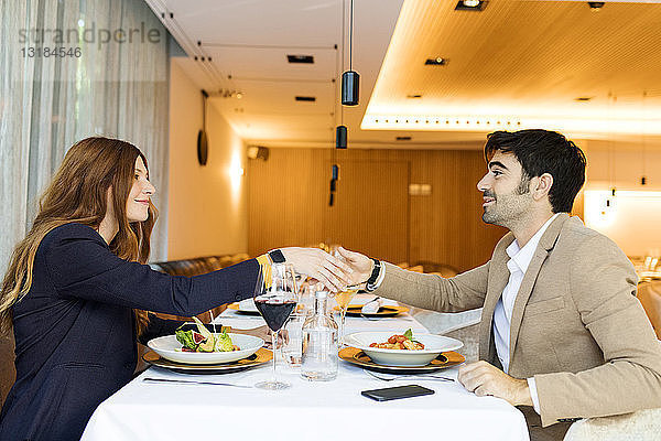 Lächelnder Mann und Frau beim Händeschütteln in einem Restaurant