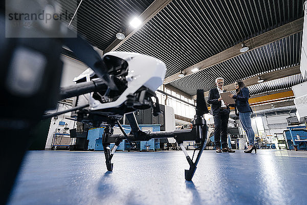 Geschäftsmann und Mitarbeiter diskutieren über die Produktion von Drohnen