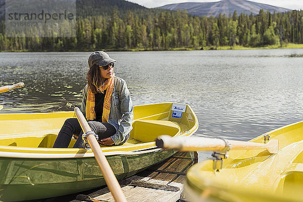 Finnland  Lappland  Frau sitzt in einem Boot auf einem See