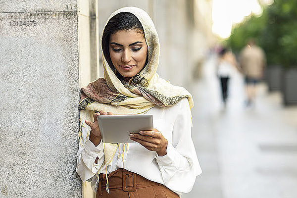 Spanien  Granada  junge muslimische Frau trägt Hijab mit Tablette im Freien