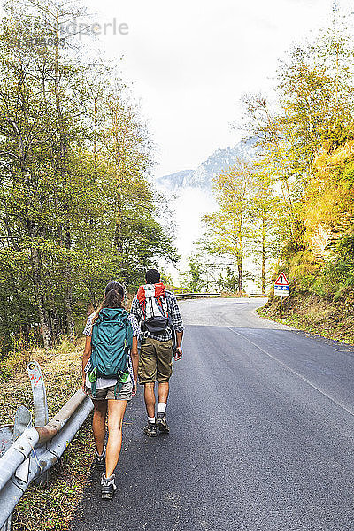Italien  Massa  Rückansicht eines jungen Paares auf einer Asphaltstrasse in den Alpi Apuane