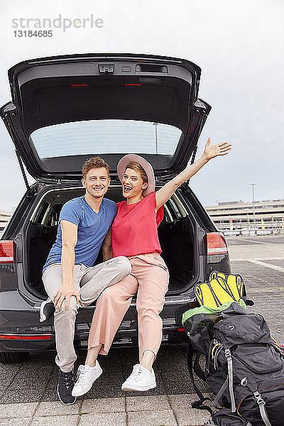 Porträt eines glücklichen jungen Paares in einem Auto auf dem Flughafen