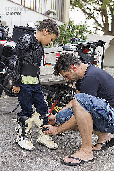 Vater bereitet seinen Sohn auf eine Motorradreise vor