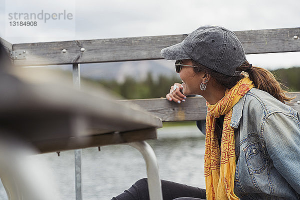 Finnland  Lappland  lächelnde junge Frau auf dem Steg am See