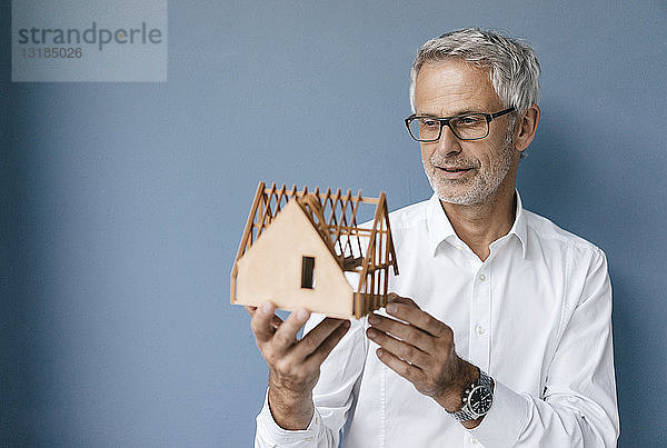 Erfolgreicher Architekt betrachtet Modell eines Hauses