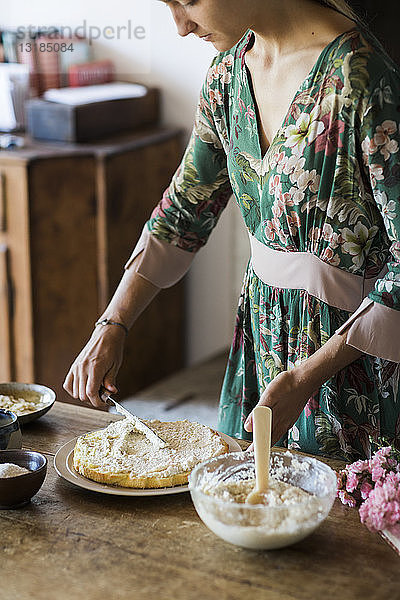 Junge Frau bereitet selbstgebackenen Kuchen zu