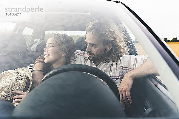 Zärtliches junges Paar in einem Auto