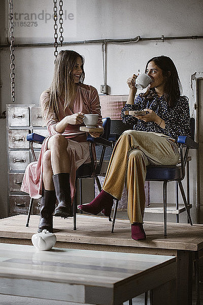 Zwei Freunde trinken gemeinsam Tee auf einem Dachboden