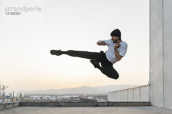 Mann macht Breakdance in städtischem Betongebäude  springt in die Luft