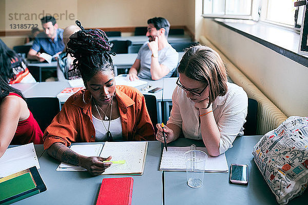 Hochwinkelansicht von multiethnischen Frauen beim Lesen von Notizen in der Sprachschule