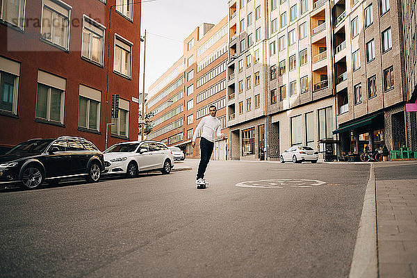 Skateboardfahren in voller Länge auf der Straße in der Stadt