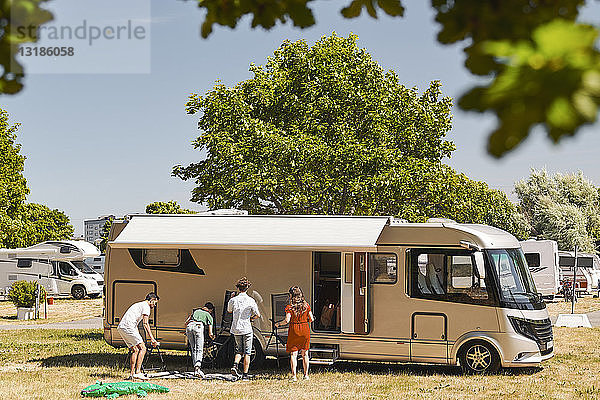 Familie gegen Wohnmobil-Camping im Wohnwagenpark während der Sommerferien