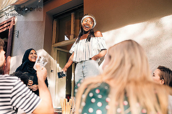 Multi-ethnische junge Freunde feiern während der Party auf dem Balkon