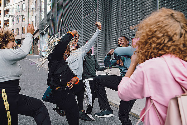 Glückliche Freunde tanzen auf der Straße mit einer Frau im Vordergrund