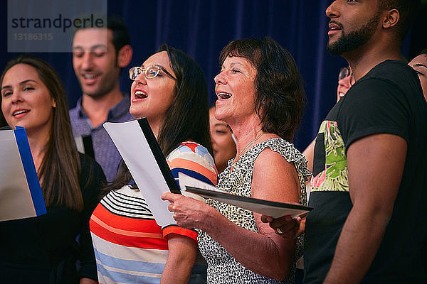 Multi-ethnische Chorsänger auf der Bühne im Auditorium