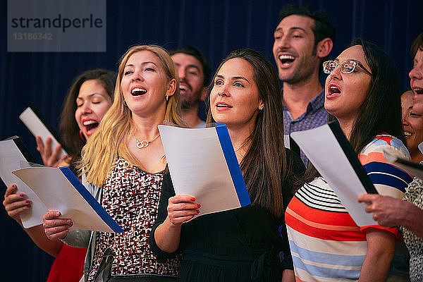 Multi-ethnische Freunde singen bei Chorprobe in Sprachschule