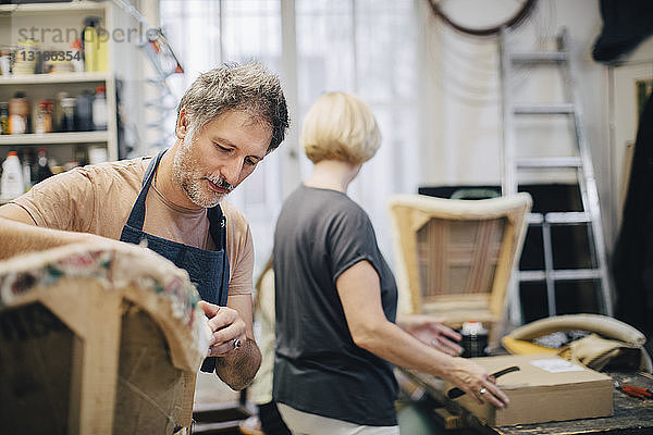 Reife Handwerker nähen Sofa in der Werkstatt