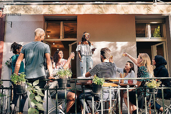 Multiethnische Freunde genießen während einer Party auf dem Balkon