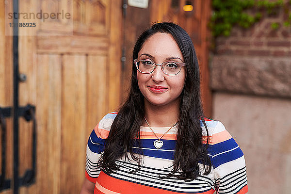 Porträt einer jungen Frau mit Brille vor der Sprachschule