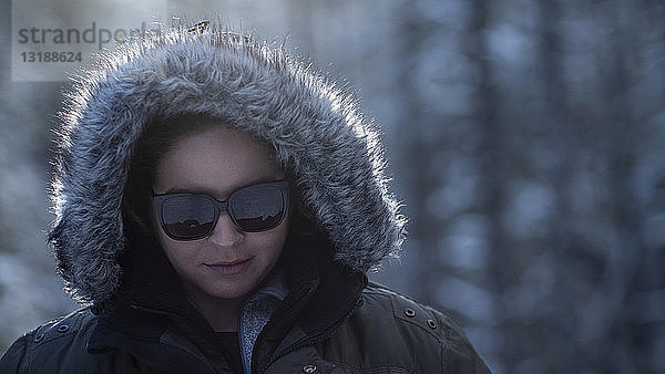 Portrait Frau mit Winterpelzhaube und Sonnenbrille