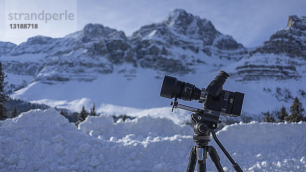 Videokamera auf Stativ unter verschneiter Berglandschaft  Banff  Alberta  Kanada
