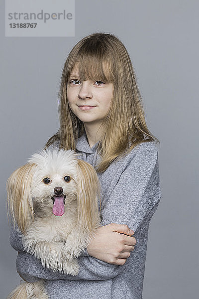 Porträt lächelnd tween Mädchen hält Hund