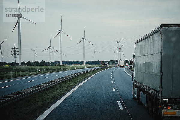 Lastwagen und Autos fahren auf der Autobahn entlang von Windkraftanlagen  Brandenburg  Deutschland