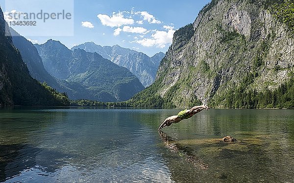 Junger Mann springt in den Obersee  hinter Watzmannmassiv  Salet am Königssee  Nationalpark Berchtesgaden  Berchtesgadener Land  Oberbayern  Bayern  Deutschland  Europa