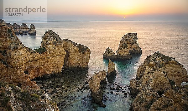 Sonnenaufgang über dem Meer  zerklüftete Felsküste aus Sandstein  Felsformationen im Meer  Ponta da Piedade  Algarve  Lagos  Portugal  Europa
