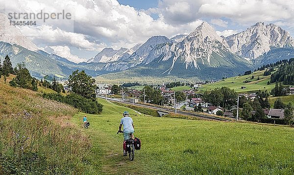 Radfahrer auf Radtour mit Mountainbike  auf dem Radweg Via Claudia Augusta  im Rücken Ehrwalder Sonnenspitze  Alpenüberquerung  Berglandschaft  Alpen  Ehrwalder Becken  bei Ehrwald  Tirol  Österreich  Europa