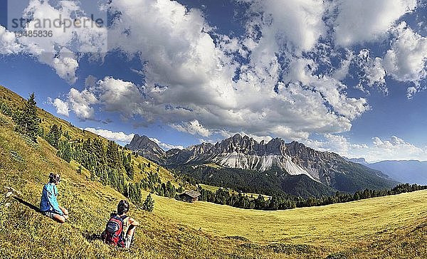 Wanderer sitzen in der Nähe der Enzianhütte auf dem Plosen und genießen den Blick auf die Afer-Geisler-Gruppe und den Peitlerkofel  Würzjochkamm  Villnösstal  Dolomiten  Provinz Bozen  Italien  Europa