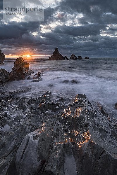 Zerklüftete Küste bei Sonnenuntergang  Felsen im Meer  Wolkenstimmung  Greymouth  Westküste  Südinsel  Neuseeland  Ozeanien