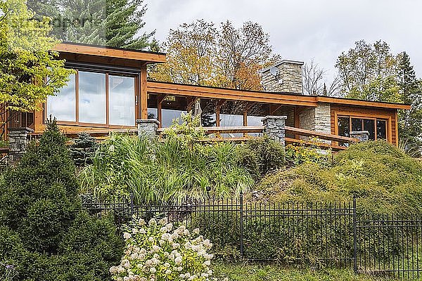 Rückansicht eines luxuriösen Hauses aus gebeiztem Zedernholz und Holz mit Panoramafenstern und Landschaftsgestaltung im Herbst  Quebec  Kanada  Nordamerika