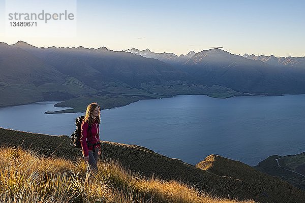 Wanderin am Isthmus Peak  Lake Wanaka und Bergpanorama bei stimmungsvollem Abendlicht  Otago  Südinsel  Neuseeland  Ozeanien