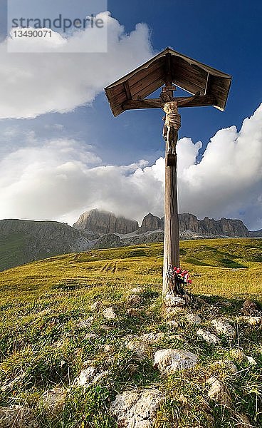 Kreuz am Passo Pordoi mit Blick auf bizarre Wolkenformationen und das Sellamassiv  Provinz Bozen  Italien  Europa