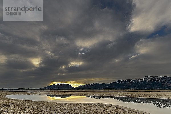 Gerissener  trockener Boden mit WasseroberflÃ¤che und AllgÃ¤u Alpen im Hintergrund  Forggensee  FÃ¼ssen  OstallgÃ¤u  Bayern  Deutschland  Europa