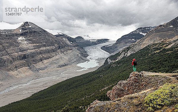 Wanderer auf einem Felsen stehend  Blick in Tal mit Gletscherzunge  Parker Ridge  Saskatchewan Glacier  Athabasca Glacier  Jasper National Park National Park  Canadian Rocky Mountains  Alberta  Kanada  Nordamerika