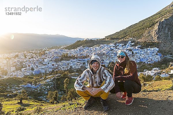 Junges Paar in marokkanischer Djellaba am Aussichtspunkt  Blick auf die Medina von Chefchaouen  Chaouen  Tanger-Tétouan  Marokko  Afrika