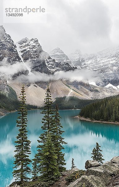 Wolken  die zwischen den Bergspitzen hängen  Spiegelung im türkisfarbenen Gletschersee  Moraine Lake  Valley of the Ten Peaks  Rocky Mountains  Banff National Park  Provinz Alberta  Kanada  Nordamerika