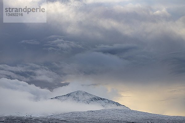 Schneebedeckter Berggipfel mit Wolken in schneebedeckter Landschaft  Sligachan  Portree  Isle of Sky  Schottland  Vereinigtes Königreich  Europa