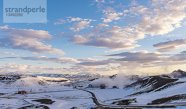 Abendstimmung  Straße durch verschneite Vulkanlandschaft  Geothermisches Kraftwerk Krafla  Isländisches Hochland  Vulkan Krafla  bei Mývatn  Nordisland  Island  Europa