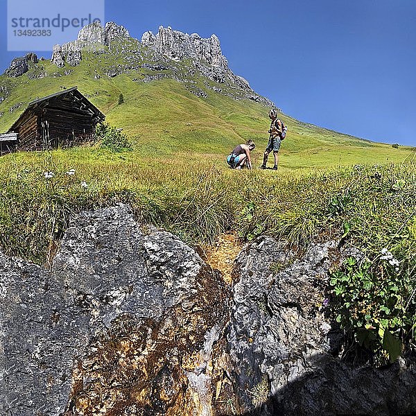 Kleine Quelle am Peitlerkofel  Sasso delle Putia  mit Wanderern und Berghütte  Würzjoch  Erbepass  Villnöss  Fünen  Dolomiten  Südtirol  Italien  Europa