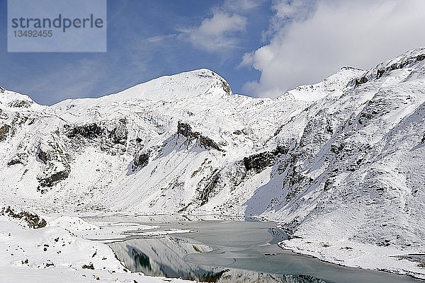 Stausee Naßfeld auf 2233 m an der Großglockner Hochalpenstraße mit verschneiten Bergen  Kapuziner 2852 m  Schartenkopf 2857 m und Untere Pfandlscharte  Nationalpark Hohe Tauern  Kärnten  Österreich  Europa