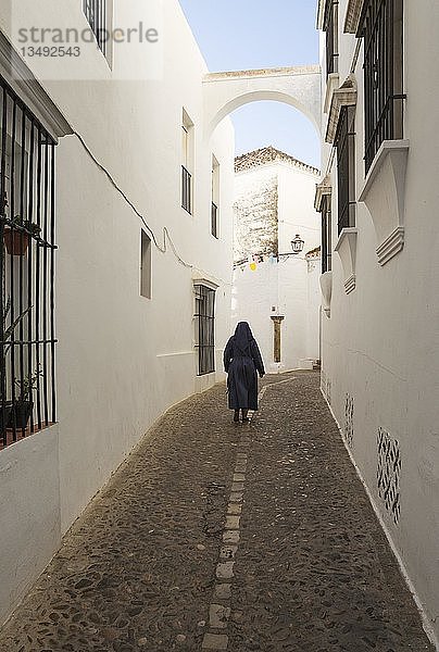 Nonne in einer Gasse mit weiß getünchten Häusern  Weiße Stadt Arcos de la Frontera  Provinz Cádiz  Andalusien  Spanien  Europa