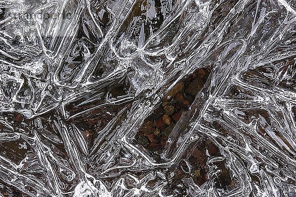 Eiskristalle  die sich auf einer gefrorenen Pfütze bilden