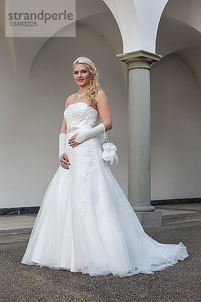 Junge Frau im weißen langen Hochzeitskleid