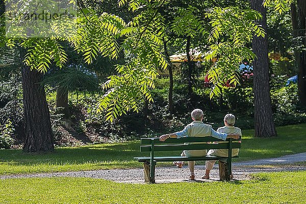 Älteres Paar genießt die Frühlingssonne auf einer Parkbank  Deutschland  Europa