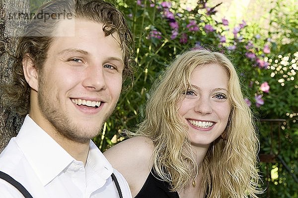 Ein junges Paar sitzt im Garten  direkter Blick  Deutschland  Europa