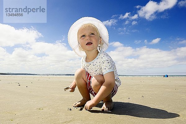Kleines Mädchen sitzt am Strand  Bretagne  Frankreich  Europa